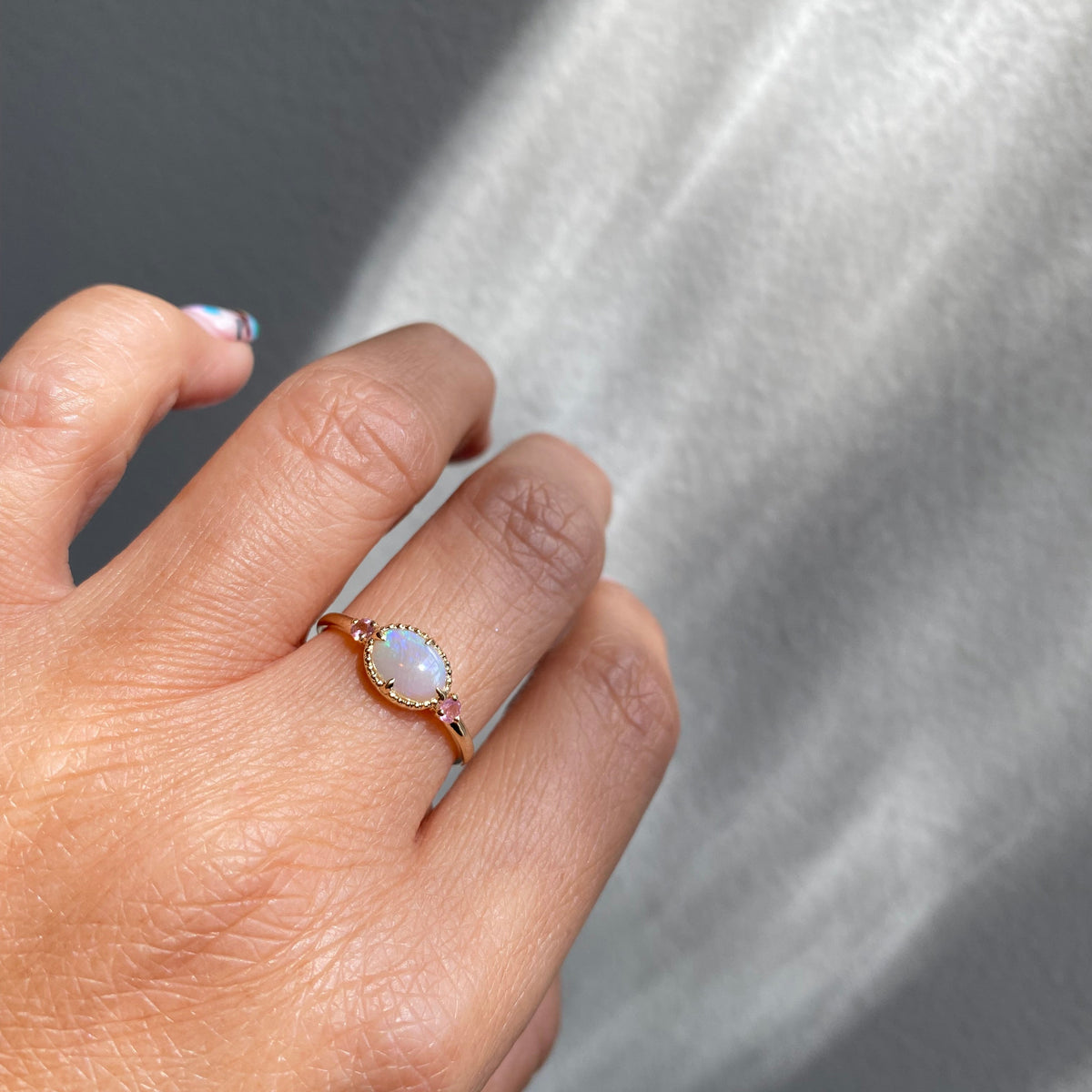 Oval beaded bezel opal ring with pink tourmaline side stones